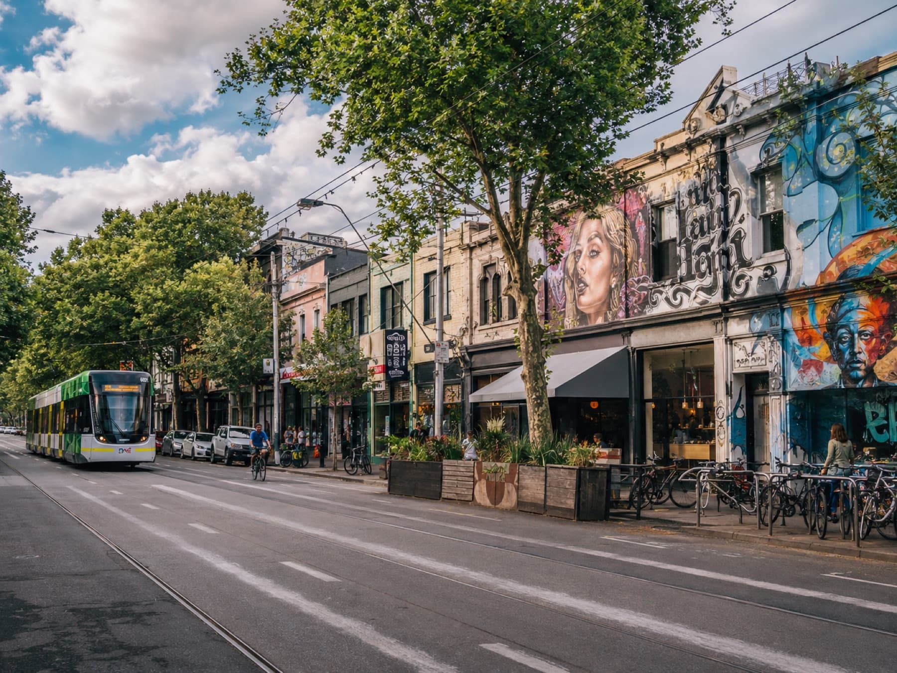 A tram on a mural-lined inner north street at dusk